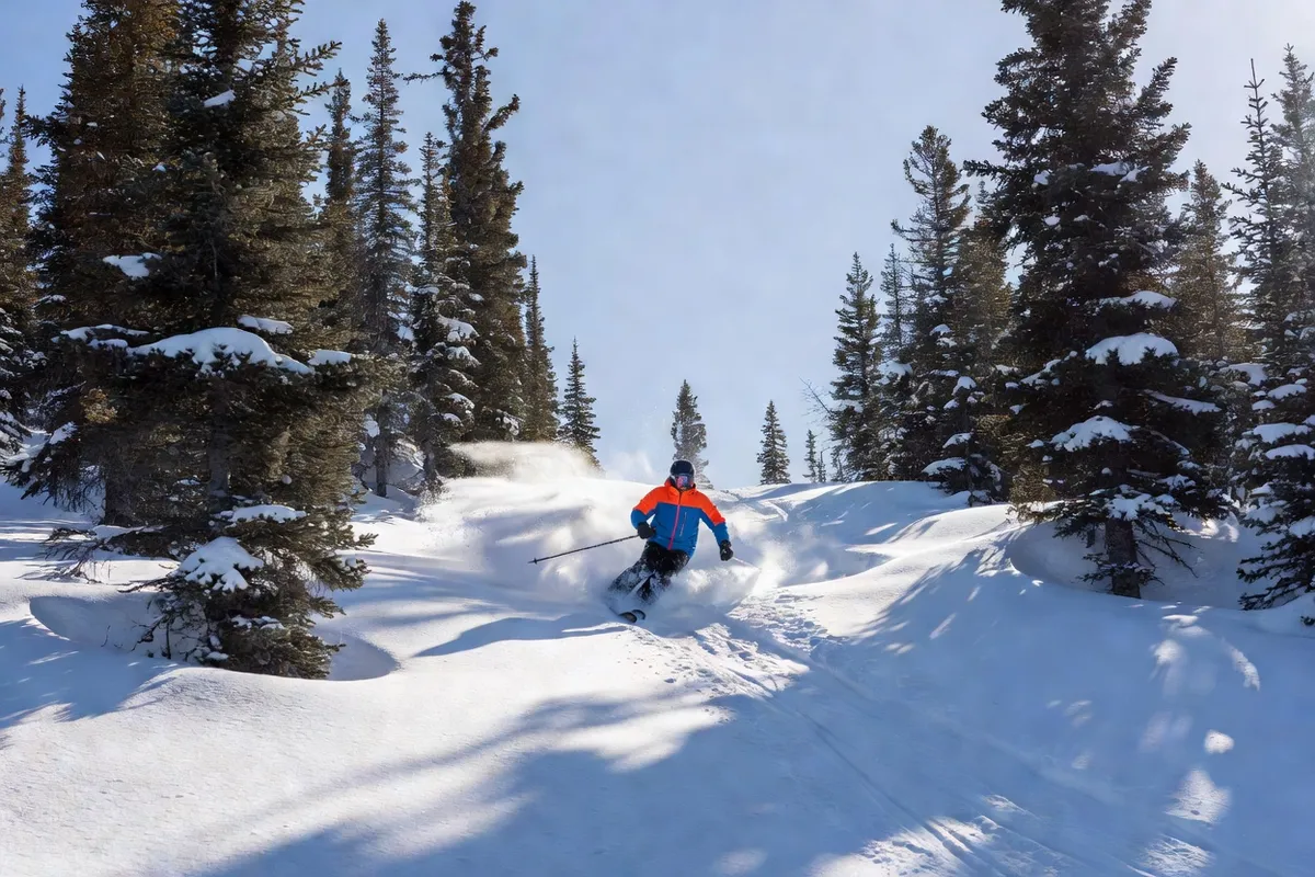 Skier in a snowy glade at a Quebec ski resort on a sunny day
